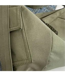Dettaglio della borsa in tela verde militare con tasca laterale e trama in velluto