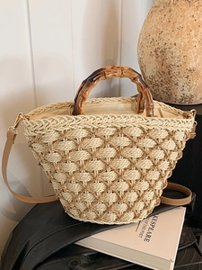 Handwoven straw tote bag with bamboo handles and crossbody strap for beach vacations