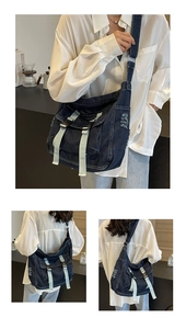 Detail of dark blue denim messenger bag with distressed edges and double buckle closures