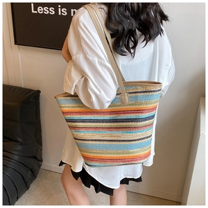 Detailed view of colorful striped woven tote bag with brown faux leather shoulder straps
