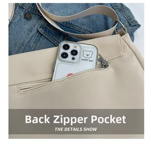 Detail of the back zipper pocket on the large capacity cream canvas shoulder bag