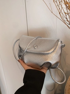 Silver metallic cloud crossbody bag with textured leather and a minimalist button
