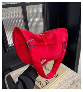 Detail of red crescent crossbody bag with double zipper and adjustable wide shoulder strap