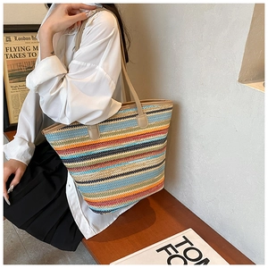 Detail of multi-color striped woven tote bag with slim straps for summer style