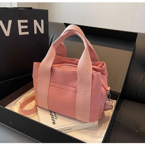 Detailed view of pink canvas tote bag with adjustable shoulder strap in premium packaging