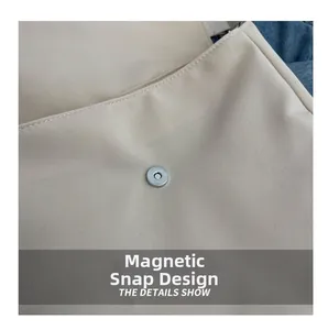 Close-up of the secure magnetic buckle design on this beige canvas shoulder bag