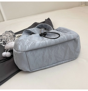 Detail of the light blue marble texture handbag with drawstring closure and wide strap