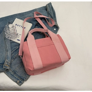 Detailed view of pink canvas tote bag with adjustable shoulder strap and sturdy handles