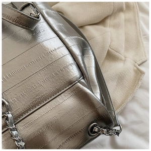 Close-up of metallic silver bag with lizard texture and exquisite chain strap detail