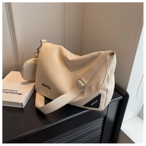 Détail d'un grand sac bandoulière blanc cassé avec sangle réglable et petit porte-monnaie