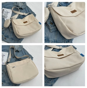 Detail view of beige canvas messenger bag with a small detachable round pouch