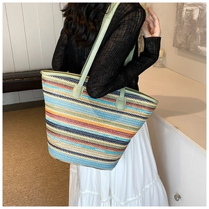 Detailed macro view of colorful striped straw tote bag showing woven texture and strap