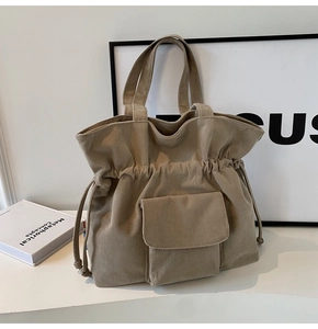Close-up of beige corduroy tote bag featuring thick ribbed texture and drawstring closure