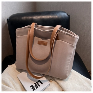 Detail view of large color-block tote bag in beige felt with brown leather shoulder straps