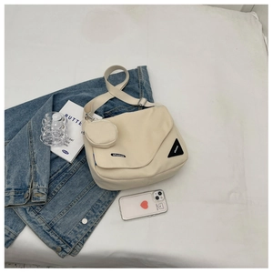 Détail du grand sac messager en toile avec bandoulière réglable et petit porte-monnaie