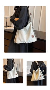 Detail view of large cream canvas tote bag with brown circular vintage leather logo