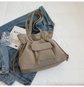 Primer plano de bolso tote de pana caqui con textura de rayas y cordón de ajuste