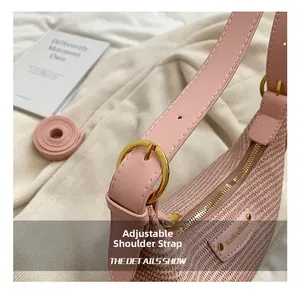 Vue détaillée d'un sac en paille rose avec bandoulière réglable et boucle en métal