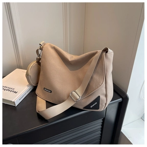 Vue détaillée du sac bandoulière en nylon beige avec petit porte-monnaie rond et large sangle