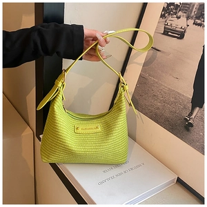 Gros plan détaillé d'un sac à main tressé vert avec plaque logo et fine bandoulière