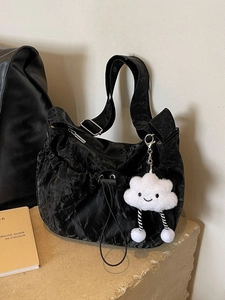 Black crinkled shoulder bag with drawstring and cute cloud charm on stone base