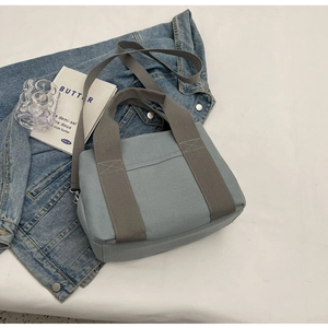 Flat lay of light blue canvas tote bag with gray straps and extra long shoulder strap