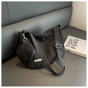 Détail du sac en toile noire avec porte-monnaie amovible et boucle en métal argenté