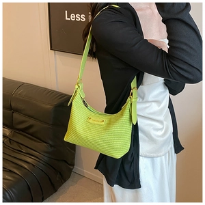 Gros plan d'un sac à bandoulière tressé vert fluo avec sangle en cuir sur un mannequin