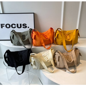 Dettaglio di borse a tracolla in nylon in sei colori su gradini bianchi in stile minimalista