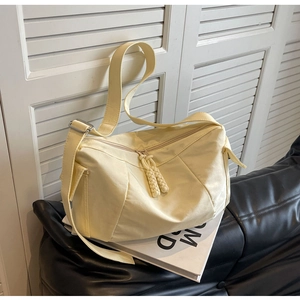 Dettaglio borsa a tracolla in nylon crema con zip in corda intrecciata e cinturino