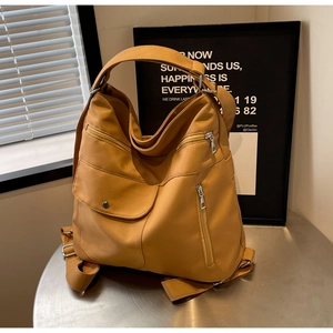 Dettaglio dello zaino in nylon giallo senape con tasche multiple e chiusura a patta