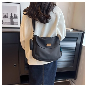 Detail of black messenger bag with shoulder strap coin pouch and Shulnuo logo patch