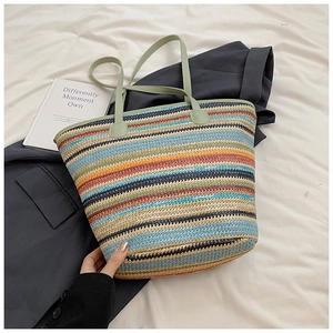 Detail of multi-color striped woven tote bag with light green leather handles