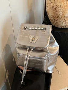Silver metallic chain backpack with butterfly lock and horizontal quilted texture