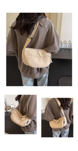 Detail of beige canvas crossbody bag featuring blue woven label and double zipper closure
