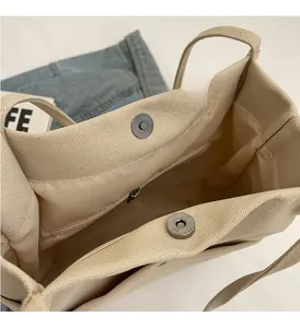 Detail of canvas bucket bag interior with magnetic snap closures and zipper pocket