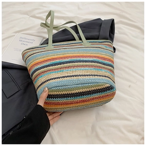 Detail of colorful rainbow striped straw woven tote bag with mint green leather strap