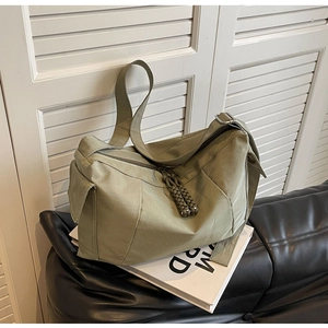 Dettaglio borsa a tracolla verde oliva con zip intrecciata e tasca laterale