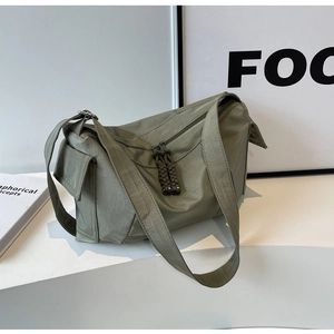 Dettaglio borsa a tracolla in nylon verde oliva con doppia zip e nodi decorativi