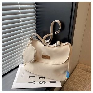 Detail of cream canvas crossbody bag with adjustable strap and small round coin purse