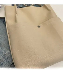 Detailed macro shot of durable cream canvas fabric with visible stitching and snap pocket