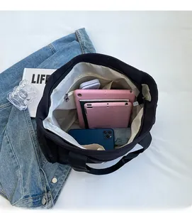 Top view showing the large capacity interior of the black canvas tote bag with essentials