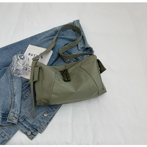 Dettaglio della borsa a tracolla in nylon verde militare con tirazip in tessuto verde