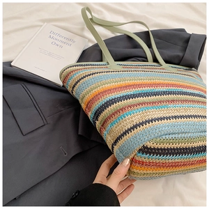 Close-up of the dense woven texture and green leather handles on the striped tote bag