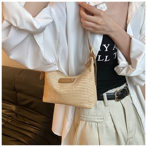 Détail du sac hobo en paille tressée avec bandoulière réglable en cuir marron
