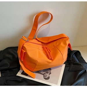 Dettaglio della borsa a tracolla arancione brillante con doppia zip e spallina regolabile