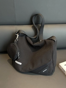 Sac bandoulière minimaliste en toile noire avec petit porte-monnaie sur la sangle