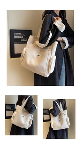 Detail view showing beige canvas tote bag with side zipper pockets and logo patch