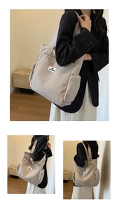 Detail of beige canvas tote bag showing side zipper pocket and fashion brand label