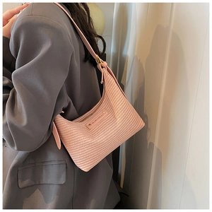 Détail du sac hobo rose clair avec texture tressée et forme élégante en demi-lune